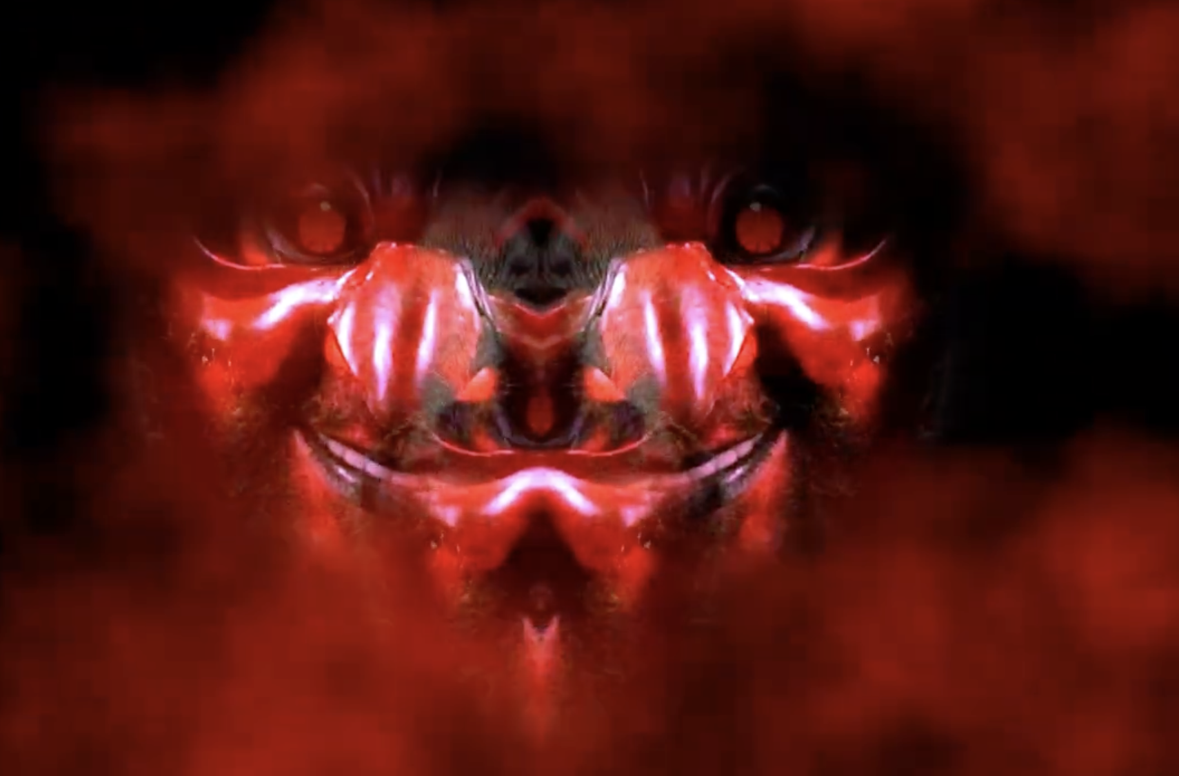a smiling devil face with red eyes surrounded by red fog